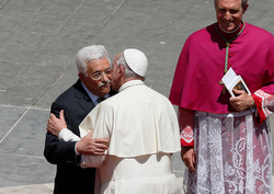 Palestinian President Mahmoud Abbas greets Pope Francis at the conclusion of the canonization Mass for four new saints in St. Peter's Square at the Vatican May 17. Also pictured is Archbishop Georg Ganswein, prefect of the papal household. Two of the saints the pope canonized are Marie-Alphonsine and Mary of Jesus Crucified, both from historic Palestine. (CNS photo/Paul Haring)