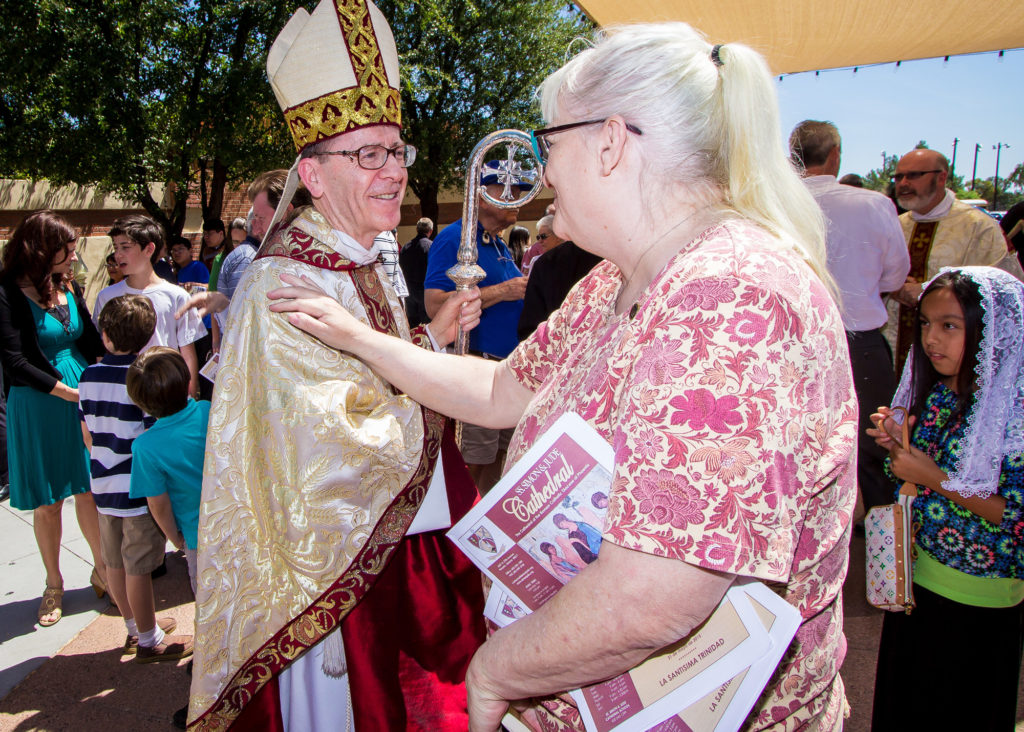 A churchgoer spends a moment chatting with Bishop Thomas J. Olmsted following the May 31 Transitional Diaconate Ordination Mass at Ss. Simon and Jude Cathedral. In her column, Joyce Coronel encourages readers to support clergy. (Billy Hardiman/CATHOLIC SUN)