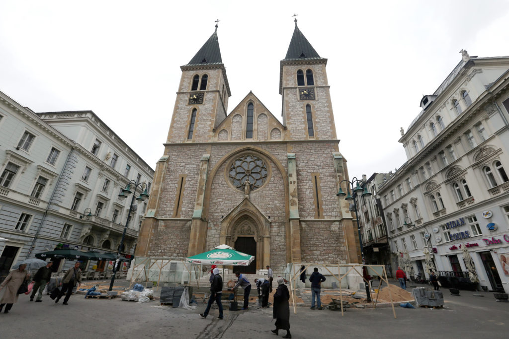 People walk outside the Cathedral of the Sacred Heart in late April in Sarajevo, Bosnia-Herzegovina. Pope Francis will meet with priests, religious and seminarians at the capital's cathedral during his June 6 trip to Sarajevo. (CNS photo/Fehim Demir, EPA) 