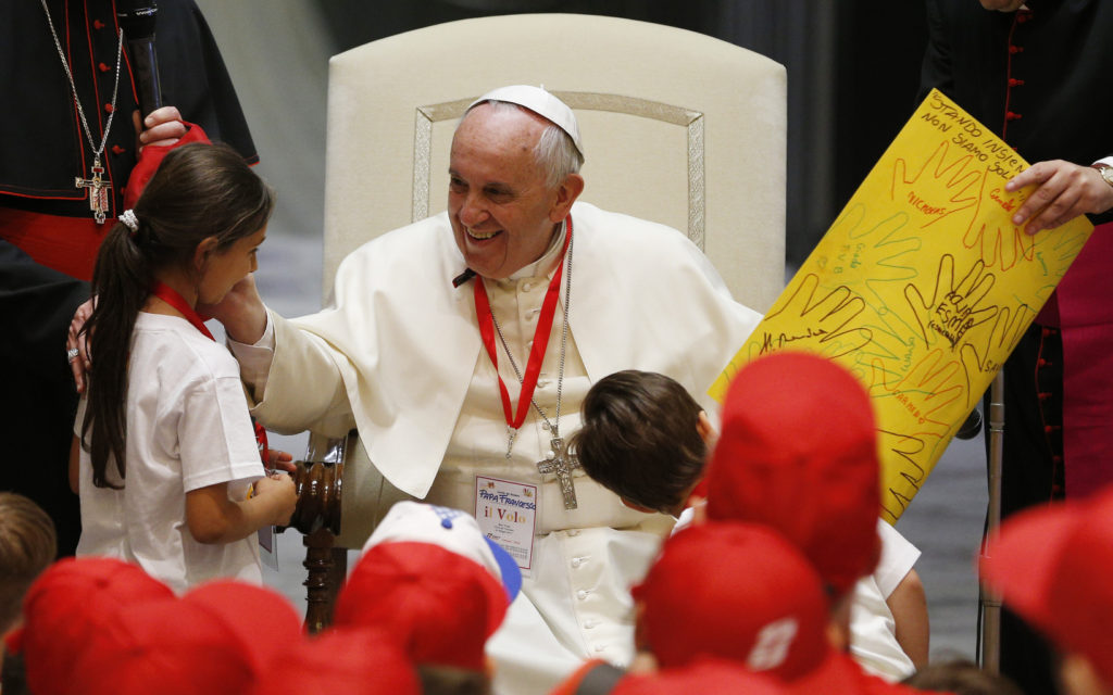 Pope Francis greets a girl after accepting a gift from her during a meeting with children of Italian prisoners in Paul VI hall at the Vatican May 30. (CNS photo/Paul Haring) 