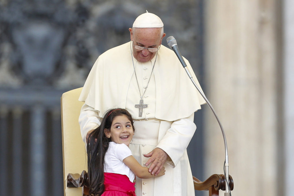 A young girl smiles as she embraces Pope Francis during an audience for families participating in the pastoral conference of the Diocese of Rome in St. Peter's Square at the Vatican June 14. (CNS photo/Giampiero Sposito, Reuters) 