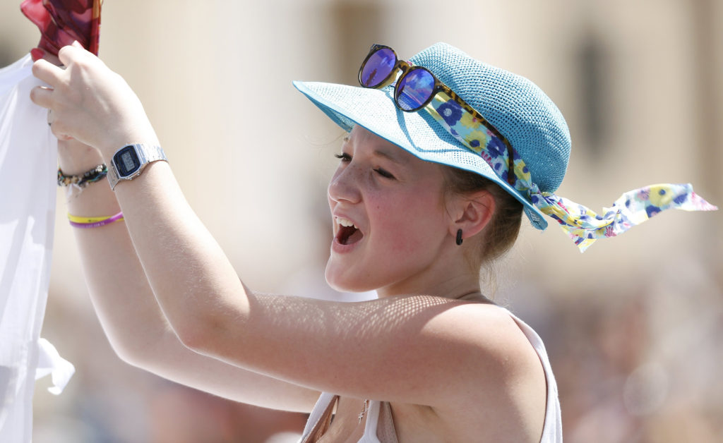 A young woman reacts as Pope Francis leads the Angelus from the window of his studio overlooking St. Peter's Square at the Vatican July 26. The pontiff officially opened online registration for World Youth Day 2016 in Poland. (CNS photo/Max Rossi, Reuters)