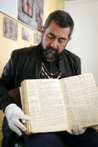 Andrew Galvan points to the entry for his great-great-great-great-grandfather in an early baptismal registry for Mission San Francisco de Asis, also known as Mission Dolores, in San Francisco May 19. Listed as number 1552, the entry shows the Christian name given, Faustino. (CNS photo/Nancy Wiechec))