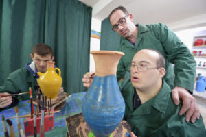 Chadi Hobeika, a special needs educator, helps residents paint pottery in late May at Phenix Group Homes, an organization in Beirut that provides residential and day care for people living with intellectual disabilities. (CNS photo/Paul Jeffrey) 