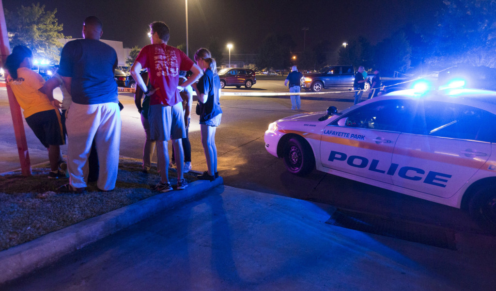 Bystanders watch over the scene at a movie theater in Lafayette, La., July 23. A gunman opened fire at the theater that evening, killing at least two people and injuring nine others before taking his own life, according to local reports. (Lee Celano/CNS via Reuters)