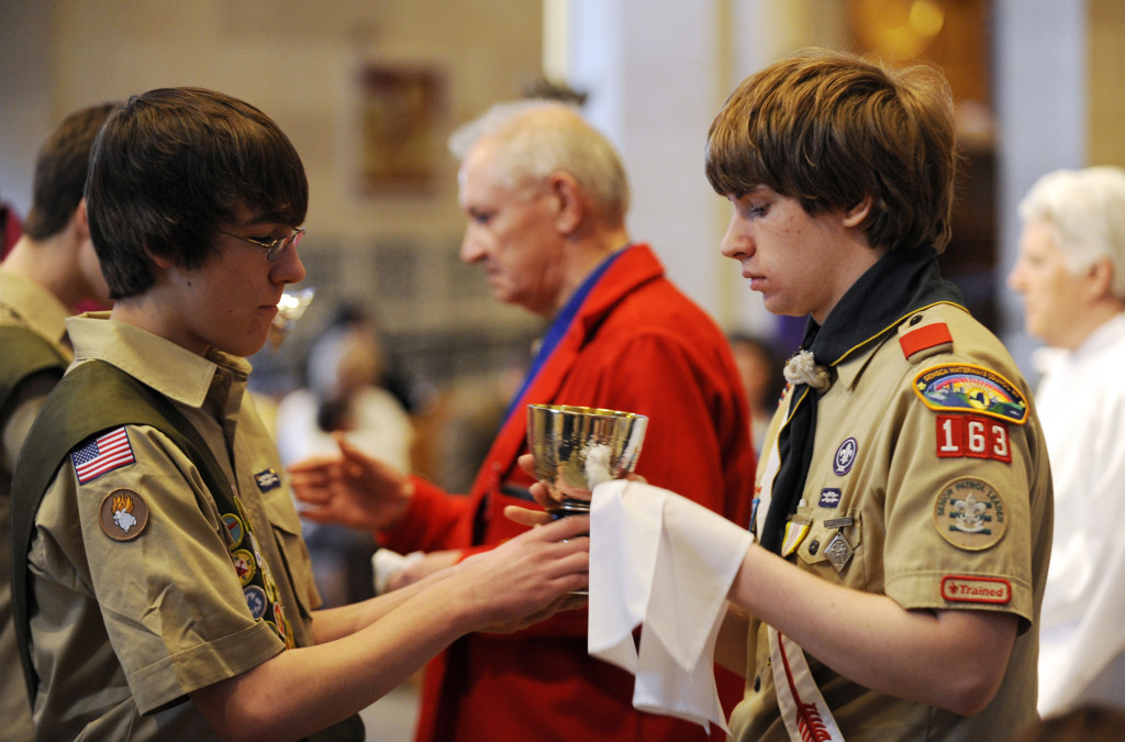 Boy Scouts serve as extraordinary ministers of holy Communion during a Catholic Scouting recognition Mass in 2010 at Sacred Heart Cathedral in Rochester, N.Y. The Boy Scouts of America lifted a ban on accepting openly gay adult volunteers and employees July 27. (Mike Crupi/CNS via Catholic Courier)