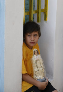 A boy holds a statue of Mary as he waits for Pope Francis' arrival to meet with people of the Banado Norte, a poor neighborhood in Asuncion, Paraguay, July 12. (CNS photo/Paul Haring) 