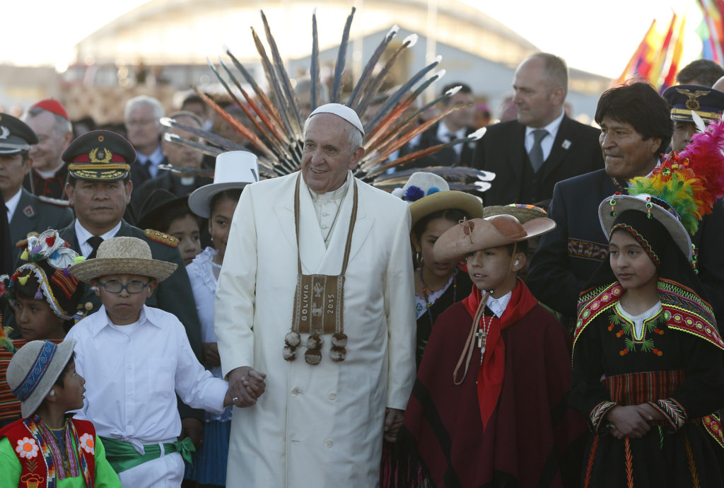 Pope Francis walks with Bolivian President Evo Morales and children in traditional dress as he arrives at El Alto International Airport in La Paz, Bolivia, July 8. The airport is more than 13,000 feet above sea level. (CNS photo/Paul Haring) 