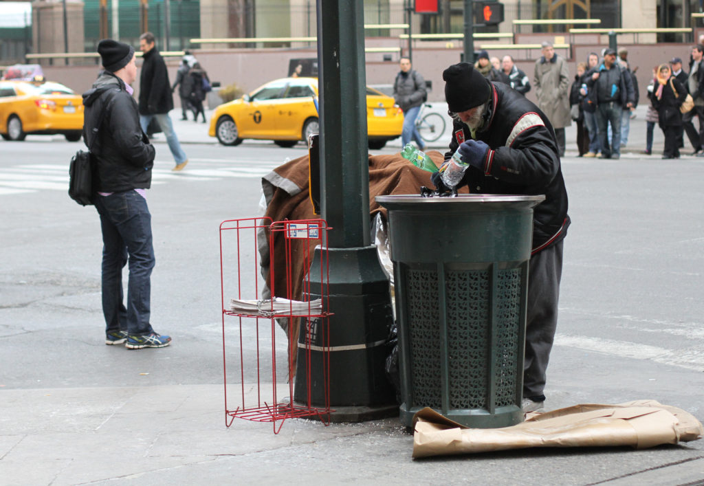 A homeless man searches a trash can for bottles and cans to redeem for money in New York City in 2014. Ahead of Pope Francis' apostolic visit to the United States in September, some are bracing themselves for more criticisms from the pope, this time directed specifically at the U.S. culture and economy. (CNS photo/Gregory A. Shemitz) 