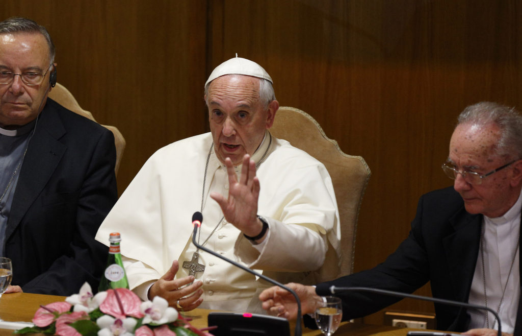 Pope Francis addresses mayors from around the world at a workshop on climate change and human trafficking in the synod hall at the Vatican July 21. Local government leaders were invited by the pontifical academies of sciences and social sciences to sign a declaration recognizing that climate change and extreme poverty are influenced by human activity. Also pictured are Cardinal Francesco Montenegro of Agrigento, Italy, left, and Cardinal Claudio Hummes, former prefect of the Congregation for the Clergy. (CNS photo/Paul Haring) 