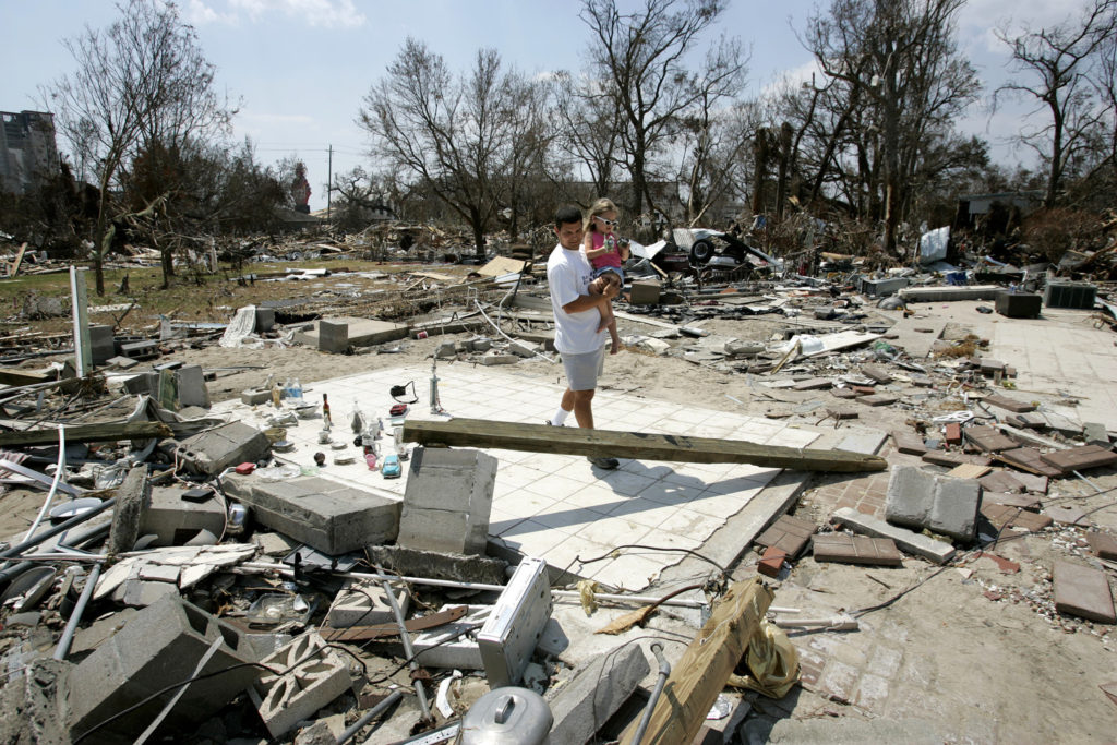 A father and daughter walk through rubble in September 2005 in Biloxi, Miss., after Hurricane Katrina devastated the Gulf Coast community. The hurricane and the failure of the New Orleans levees Aug. 29, 2005, caused more than 1,800 deaths across the coast and damaged or destroyed more than a million houses and businesses. (Bob Roller/CNS)