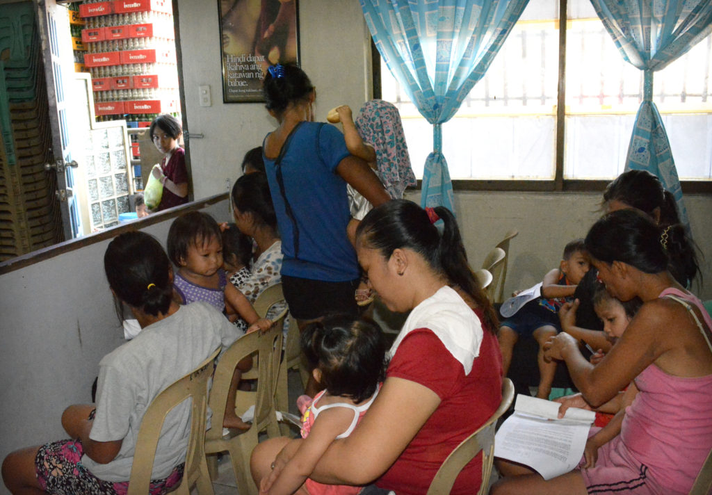 Filipino women wait in the Likhaan Women's Health Center in Manila, Philippines, Aug. 6. The center offers free contraceptives. (CNS photo/Simone Orendain) 