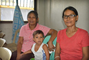 Marivic Rosana, 49, sits with one of her 12 children, while her friend and mother of five, Ninita Zamora, 50, poses for a photo in the Likhaan Women's Health Center in Manila, Aug. 6. Both women received a one-year supply of birth control pills. (CNS photo/Simone Orendain) 
