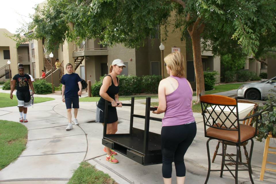 Members of Furnishing Dignity move furniture into an apartment. (Courtesy photo/Furnishing Dignity)