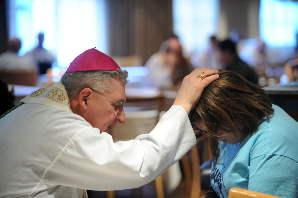 Bishop David A. Zubik of Pittsburgh hears a young woman's confession during a pro-life youth rally and Mass at the Verizon Center in Washington Jan. 22. Thousands of young people gathered at the arena to rally and pray before taking part in the 2014 March for Life. (CNS photo/Leslie Kossoff)