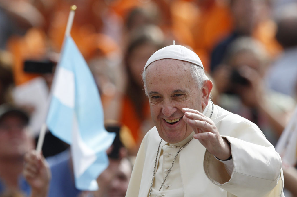 A pilgrim waves Argentina's flag as Pope Francis arrives to lead his general audience in St. Peter's Square at the Vatican Sept. 2. (CNS photo/Paul Haring)