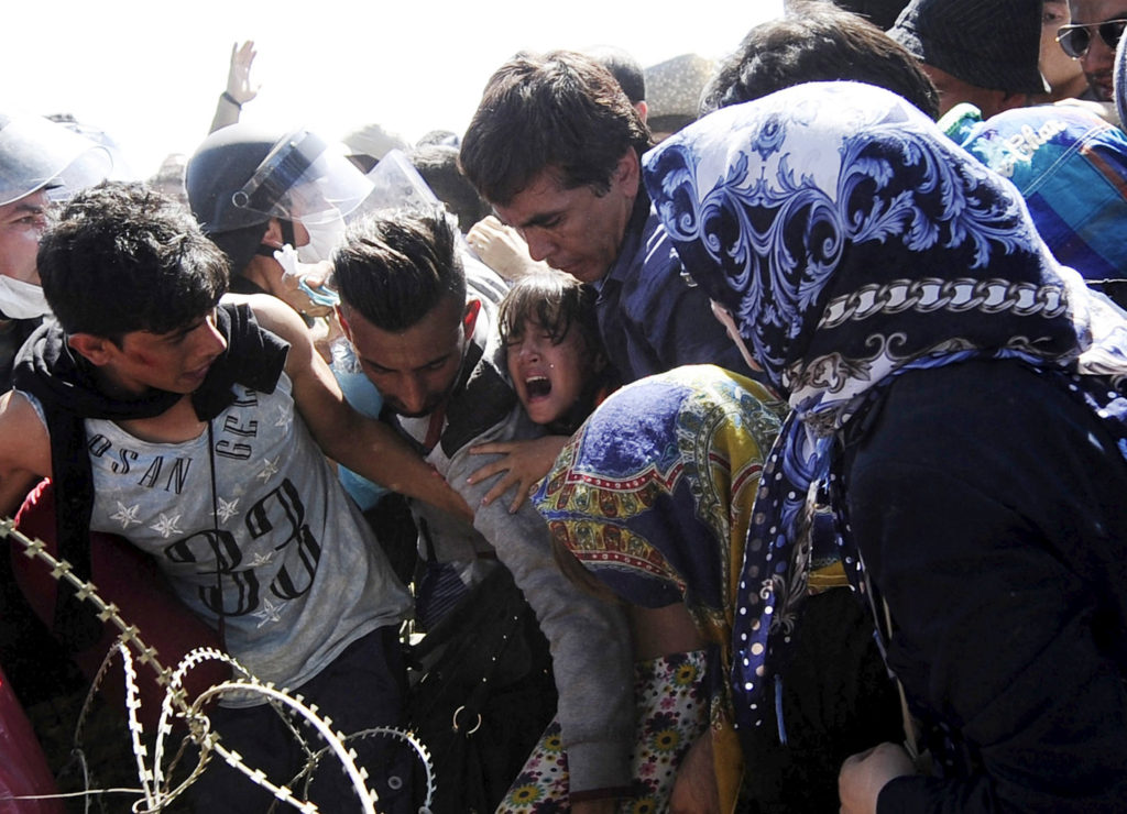 A young girl screams as migrants rush to cross into Macedonia at the Macedonian-Greek border Sept. 2. Catholic aid agencies have urged Europeans not to turn against migrants seeking refuge from Syria and other countries, in what media reports describe as the continent's greatest refugee movement since World War II. (CNS/Ognen Teofilovski, Reuters) 