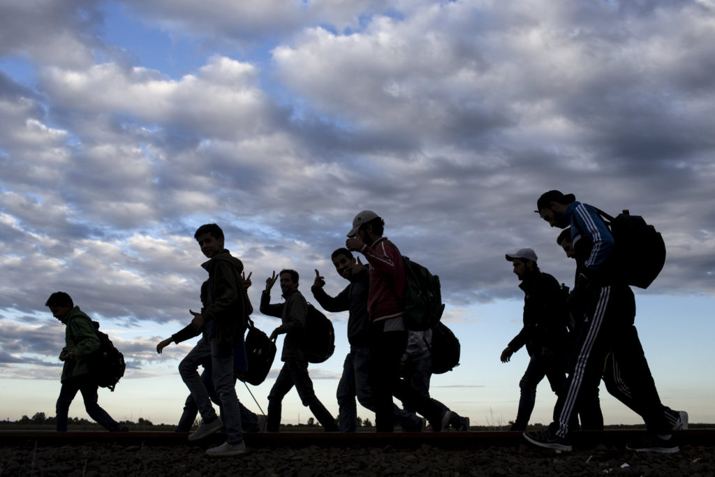 Migrants walk along rail tracks as they arrive to a collection point in the village of Roszke in Hungary after crossing the border from Serbia Sept. 6. (CNS photo/Marko Djurica, Reuters) 