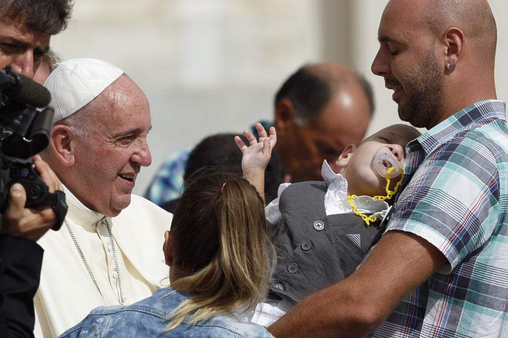 Pope Francis greets family members while meeting the disabled during his general audience in St. Peter's Square at the Vatican Sept. 16. (CNS photo/Paul Haring) 