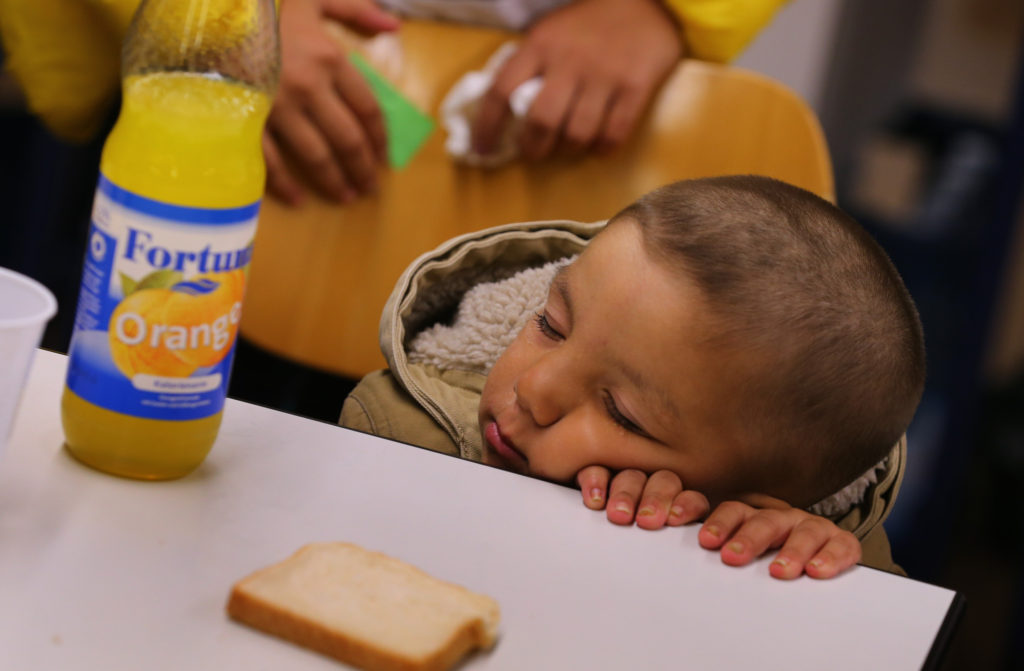 A refugee child from Iraq falls asleep at a table inside a shelter in Wertheim, Germany, Sept. 14. "Do not abandon victims" of conflicts in Syria and Iraq, Pope Francs said. (CNS photo/Karl-Josef Hildenbrand, Reuters) 