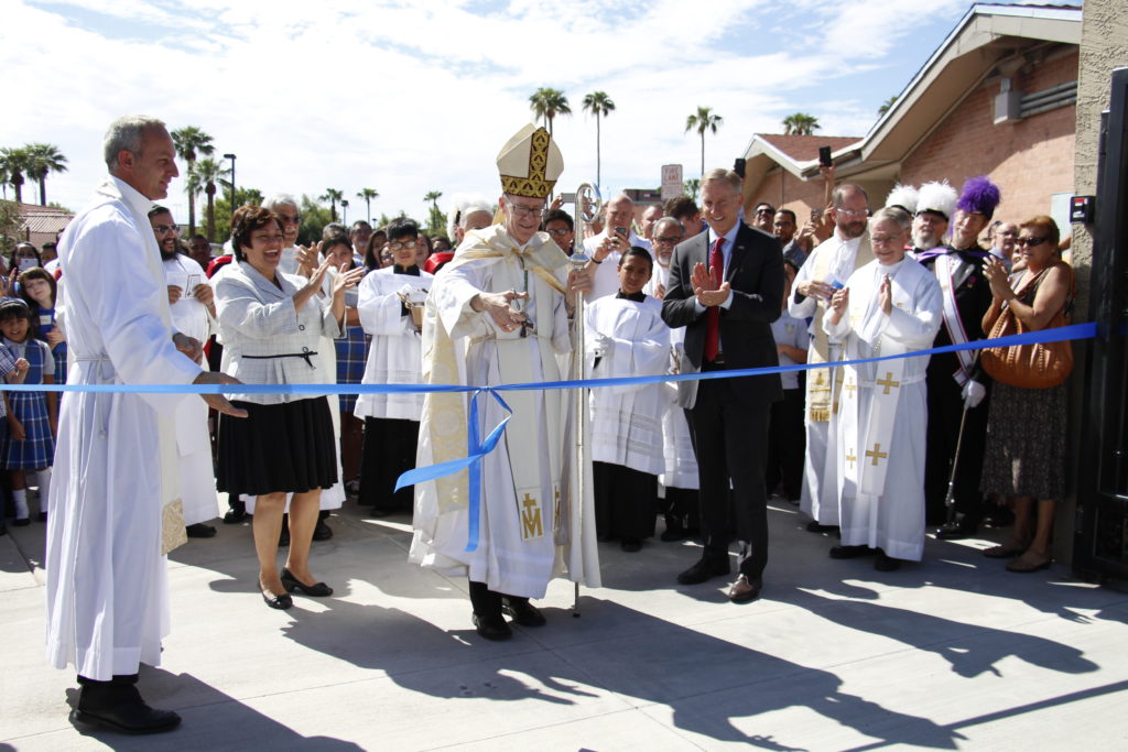 Bishop Thomas J. Olmsted cuts the ribbon Sept. 19 to usher in a new era at Queen of Peace School. The campus underwent major renovations, moved and upgraded athletic space and created a central gateway for visitors. (Ambria Hammel/CATHOLIC SUN)