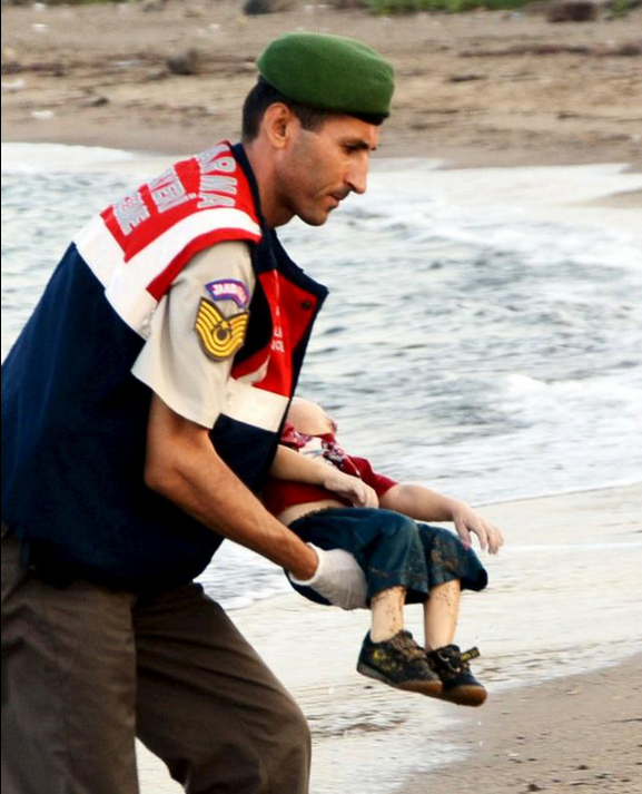 A member of the Turkish military carries a young migrant Sept. 2, who drowned in a failed attempt to sail to the Greek island of Kos, in the coastal town of Bodrum, Turkey. A Turkish media report says at least 11 migrants have died and five others are missing after boats carrying them to the Greek island of Kos capsized. (CNS photo/Reuters)
