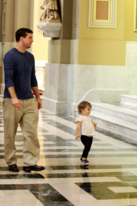 A young girl burns off some energy with her dad along a side aisle of the Cathedral Basilica of SS. Peter and Paul in Philadelphia. (Sarah Webb/Courtesy of CatholicPhilly.com)