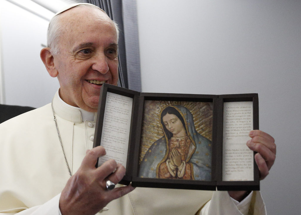 Pope Francis holds an image of Our Lady of Guadalupe aboard the papal flight to Brazil in this July 22, 2013, file photo. The pope is deeply devoted to Mary and often expresses his devotion by praying in front of Marian statues and then gently touching them. (CNS photo/Paul Haring) See VATICAN LETTER April 16, 2015.