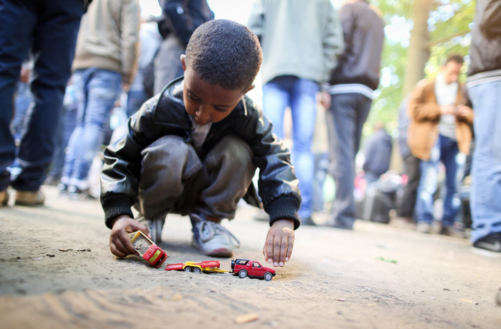 Refugee boy plays with a toy car while refugees wait for registration in Berlin, Germany, Oct. 1. (CNS photo/Kay Nietfeld, EPA) 