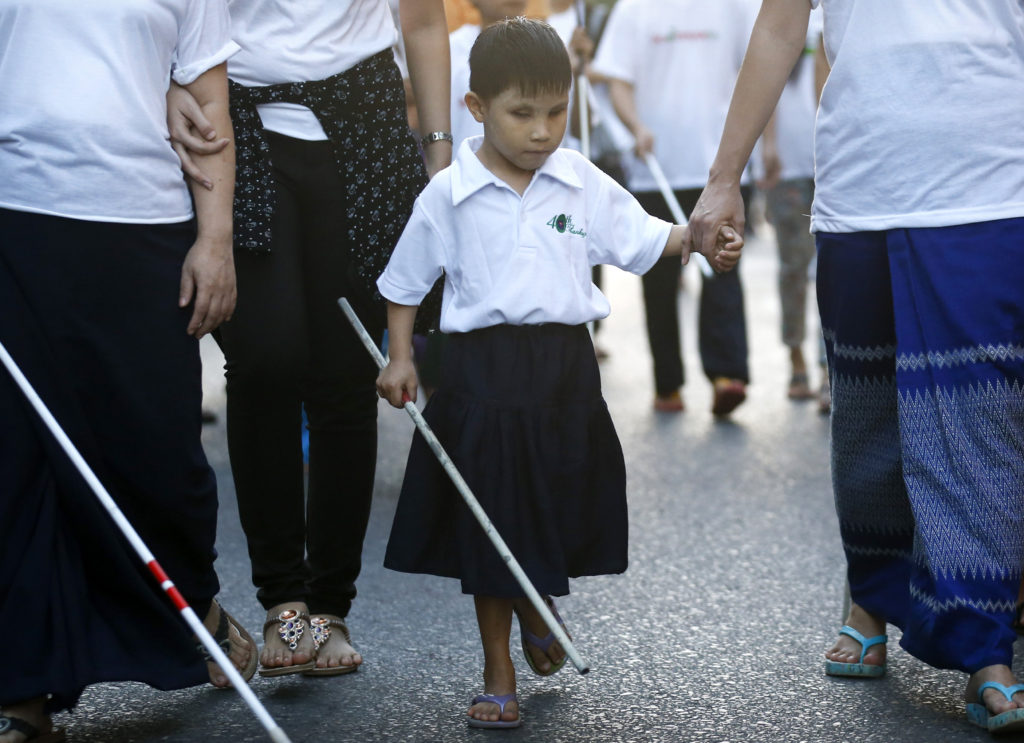 A boy along with other visually impaired people walk during a rally to mark International White Cane Day in Yangon, Myanmar, Oct. 15. While they did not grab headlines, the topics of elderly and people with disabilities, openness to life and the plight of migrants and refugees were also on the agenda of the Synod of Bishops on the family. (CNS photo/Lynn Bo Bo, EPA)