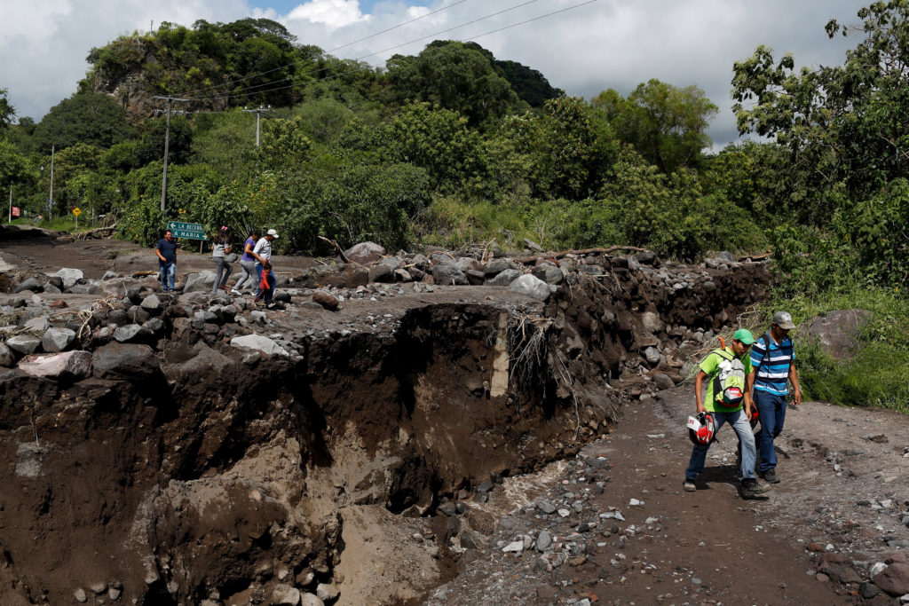 Residents walk near a damaged bridge in Comala, Mexico, Oct. 24. (CNS photo/Tomas Bravo, Reuters) 