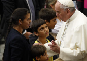 Pope Francis greets family members during an audience with Roma, Sinti and Irish Travelers and other itinerant communities in Paul VI hall at the Vatican Oct. 26. The pope called for an end to centuries of prejudice against Gypsy communities. (CNS photo/Paul Haring) 