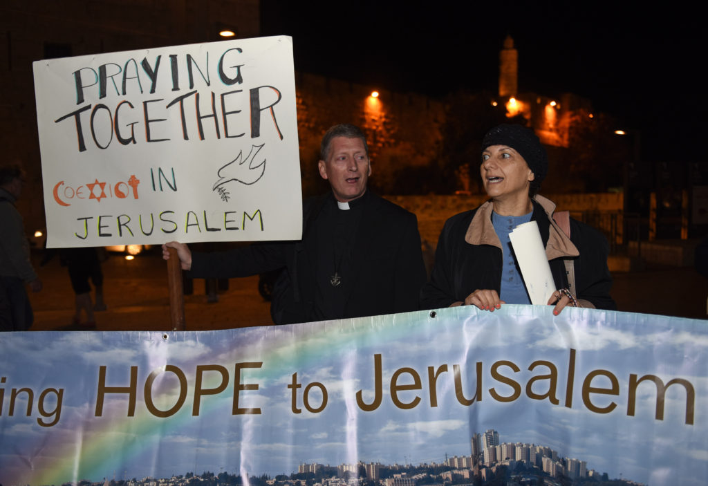 Holy Cross Father Russ McDougall, rector of Tantur Ecumenical Institute, and Peta Jones Pellach, an Orthodox Jewish woman who works for the Elijah Interfaith Institute, sing during an interfaith prayer service for peace in the Old City of Jerusalem Oct. 29. (CNS photo/Debbie Hill) 