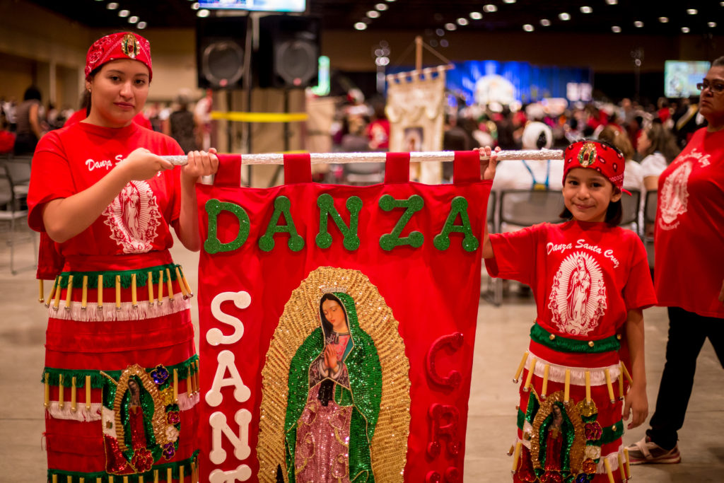 Vanessa Rodriguez and Giselle Reyes display their banner at the annual celebration. (Billy Hardiman/CATHOLIC SUN)