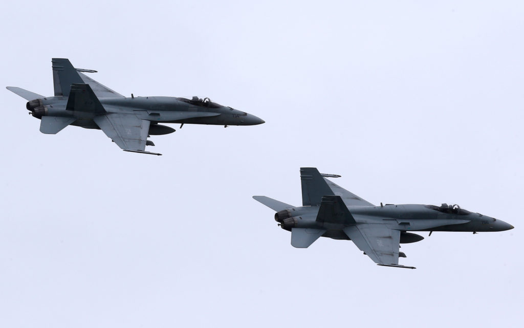 In this May 31, 2014, file photo, two Royal Canadian Air Force F-18 Hornet jets fly over Romania. Canada's new government has decided to stop airstrikes against Islamic State in the Middle East. (CNS photo/Mircea Rosca, EPA) 