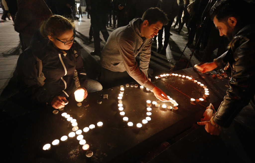 People light candles in the shape of a cross and heart in Republique square in Paris Nov. 14 in memory of victims of terrorist attacks. Coordinated attacks the previous evening claimed the lives of 129 people. The Islamic State claimed responsibility. (CNS photo/Paul Haring) 