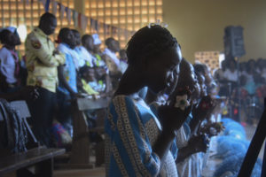 Young women pray during Mass Nov. 22 at a Catholic church adjacent to a camp for displaced persons in Bangui, Central African Republic. Pope Francis is scheduled to visit the camp during his Nov. 29-30 visit to Bangui. (CNS photo/EPA) 