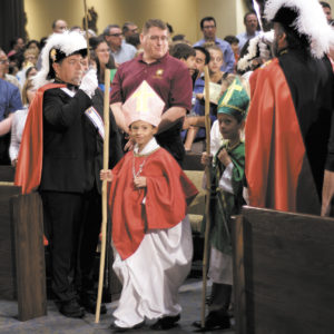Members of a Knights of Columbus honor guard salute young boys dressed as bishops during the opening procession of the Vocations Celebration All Saints Day Mass. Children were encouraged to dress as their favorite saint for the event. (Photo courtesy of Kimberly Matura, Blessed Sacrament Parish)