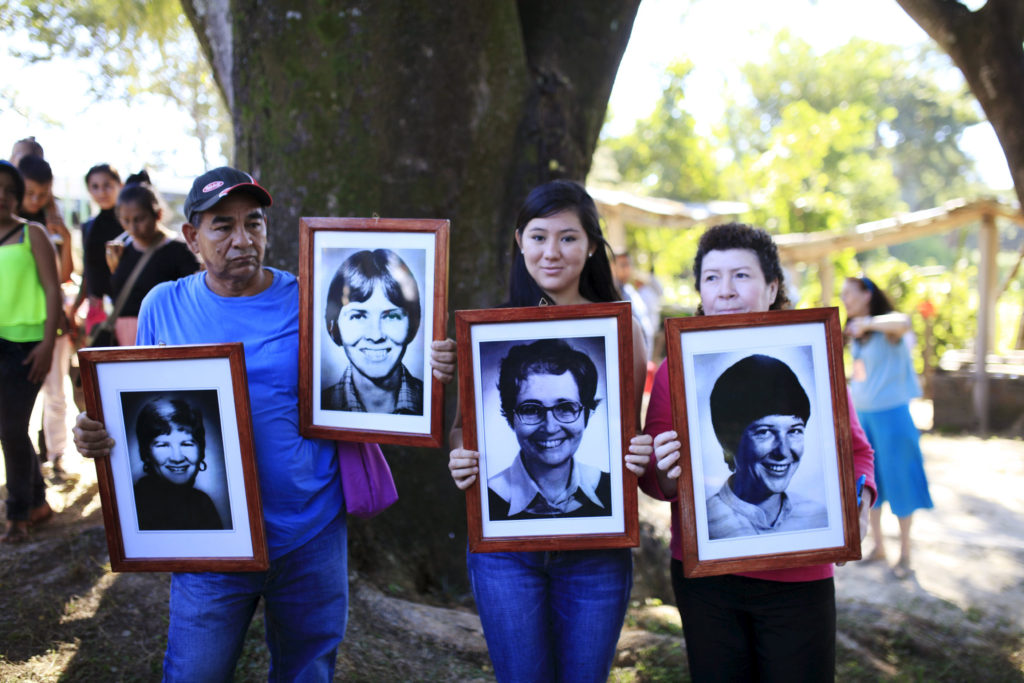 People hold pictures of four American churchwomen during a Dec. 2 memorial service to commemorate the 35th anniversary of their murder in the town of Santiago Nonualco, El Salvador. Members of Catholic and human rights organizations participated in a memorial at the place where four U.S. churchwomen, lay missioner Jean Donovan, Ursuline Sister Dorothy Kazel, Maryknoll Sisters Maura Clark and Ita Ford, were killed by members of the Salvadoran National Guard during the civil war. (CNS photo/Jose Cabezas, Reuters)