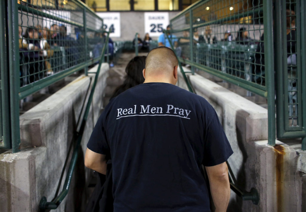 "Real Men Pray," says a T-shirt worn by an attendee of a candlelight vigil in San Bernardino, Calif., Dec. 3 for the victims of a mass shooting the previous day at the Inland Regional Center. At least 14 people were killed when gunmen opened fire during a function at a center for people with developmental disabilities. (CNS photo/Mike Blake, Reuters)