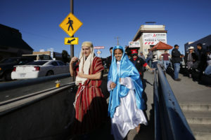 Catholic high school students Saul Gonzalez and Kenia Salas, dressed as Joseph and Mary, make their way to the DeConcini Port of Entry along the Arizona-Mexican border in Nogales, Arizona, Dec. 20. Students from Salpointe and Lourdes Catholic high schools in Arizona led a binational "posada" recalling Mary and Joseph's search for shelter before the birth of Christ. The annual event held by the Kino Border Initiative and Dioceses Without Borders reflected on the struggles of migrants and migrant families. (CNS photo/Nancy Wiechec)