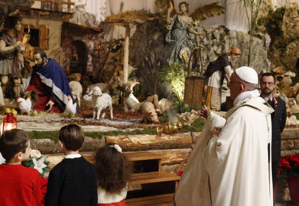 Pope Francis uses incense as he visits the Nativity scene at the conclusion of Christmas Eve Mass in St. Peter's Basilica at the Vatican Dec. 24. (CNS photo/Paul Haring)