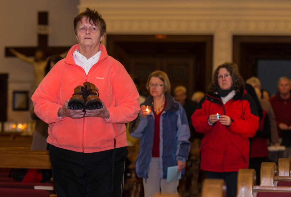 Participants at the seventh annual Greater Green Bay Area Homeless Persons' Interfaith Memorial Service, held Dec. 21 at St. John the Evangelist Church in Green Bay, Wis., join in a procession carrying shoes and candles representing homeless men and women who died in 2015. (CNS photo/Sam Lucero, The Compass) 