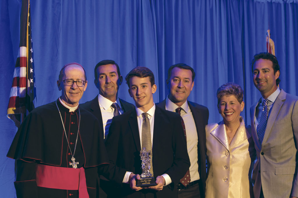 Mike and Cissy Frakes’ sons and grandson receive the Guardian of Hope Award from Bishop Thomas J. Olmsted and Catholic Schools Superintendent MaryBeth Mueller at the Night of Hope Nov. 7. The award was given to the Frakes posthumously after the couple died in a car accident earlier in the year. (John Caballero/CATHOLIC SUN)