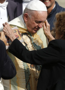 A woman places an image of Our Lady of Guadalupe on Pope Francis during his Oct. 8, 2014 general audience in St. Peter's Square at the Vatican. (Paul Haring/CNS photo)