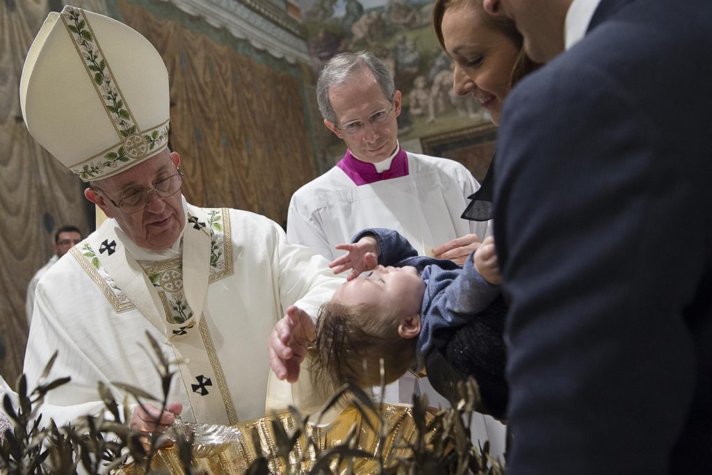 Pope Francis pours water over the head of a baby as he celebrates the baptism of 23 babies in the Sistine Chapel at the Vatican Jan. 10. The baptisms were held on the feast of the Baptism of the Lord. (CNS photo/L'Osservatore Romano, handout) 