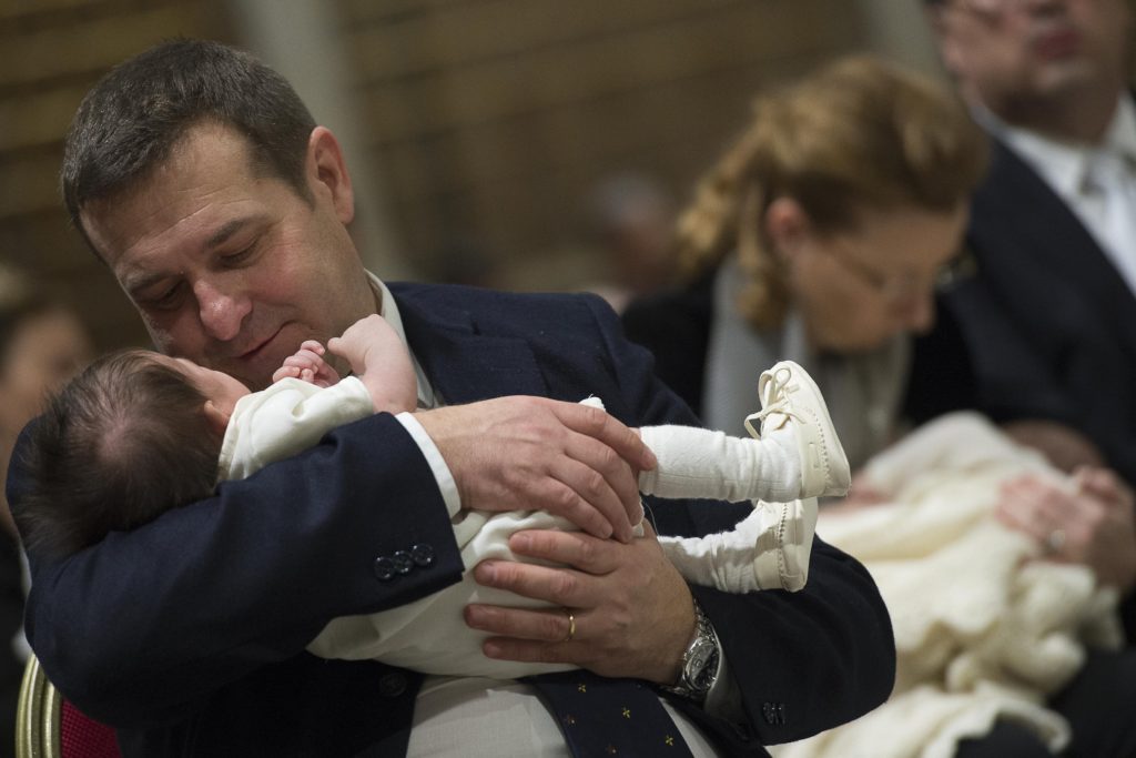 Family members hold babies as Pope Francis celebrates the baptism of 23 babies in the Sistine Chapel at the Vatican Jan. 10. The baptisms were held on the feast of the Baptism of the Lord. (CNS photo/L'Osservatore Romano, handout) 