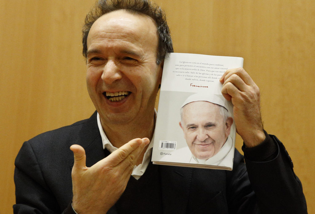 Italian actor Roberto Benigni holds a copy of the book, "The Name of God Is Mercy," during its presentation to journalists in Rome Jan. 12. The book is compiled from an interview Pope Francis did with Italian journalist Andrea Tornielli. (CNS photo/Paul Haring) 