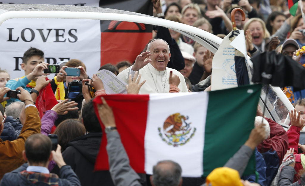 Pope Francis passes Mexico's flag as he arrives to lead his general audience in St. Peter's Square at the Vatican April 23. (CNS photo/Paul Haring) (April 23, 2014) See POPE-AUDIENCE April 23, 2014.