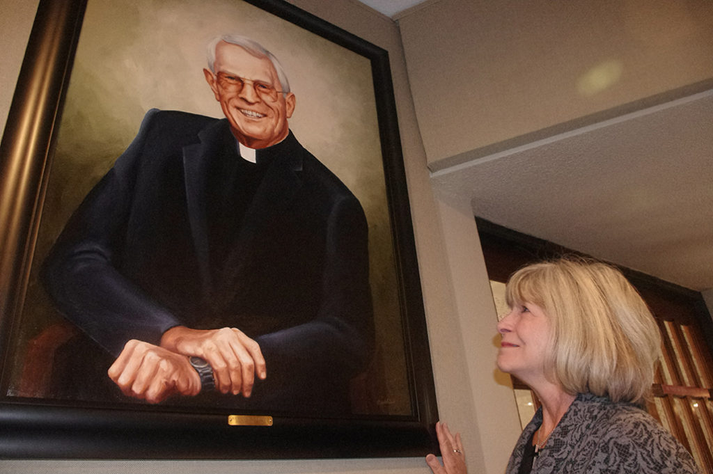 Patty Chesebrough admires a portrait of the late Fr. John Hanley, the priest who listened and helped her find God’s mercy after she had an abortion. (Joyce Coronel/CATHOLIC SUN)